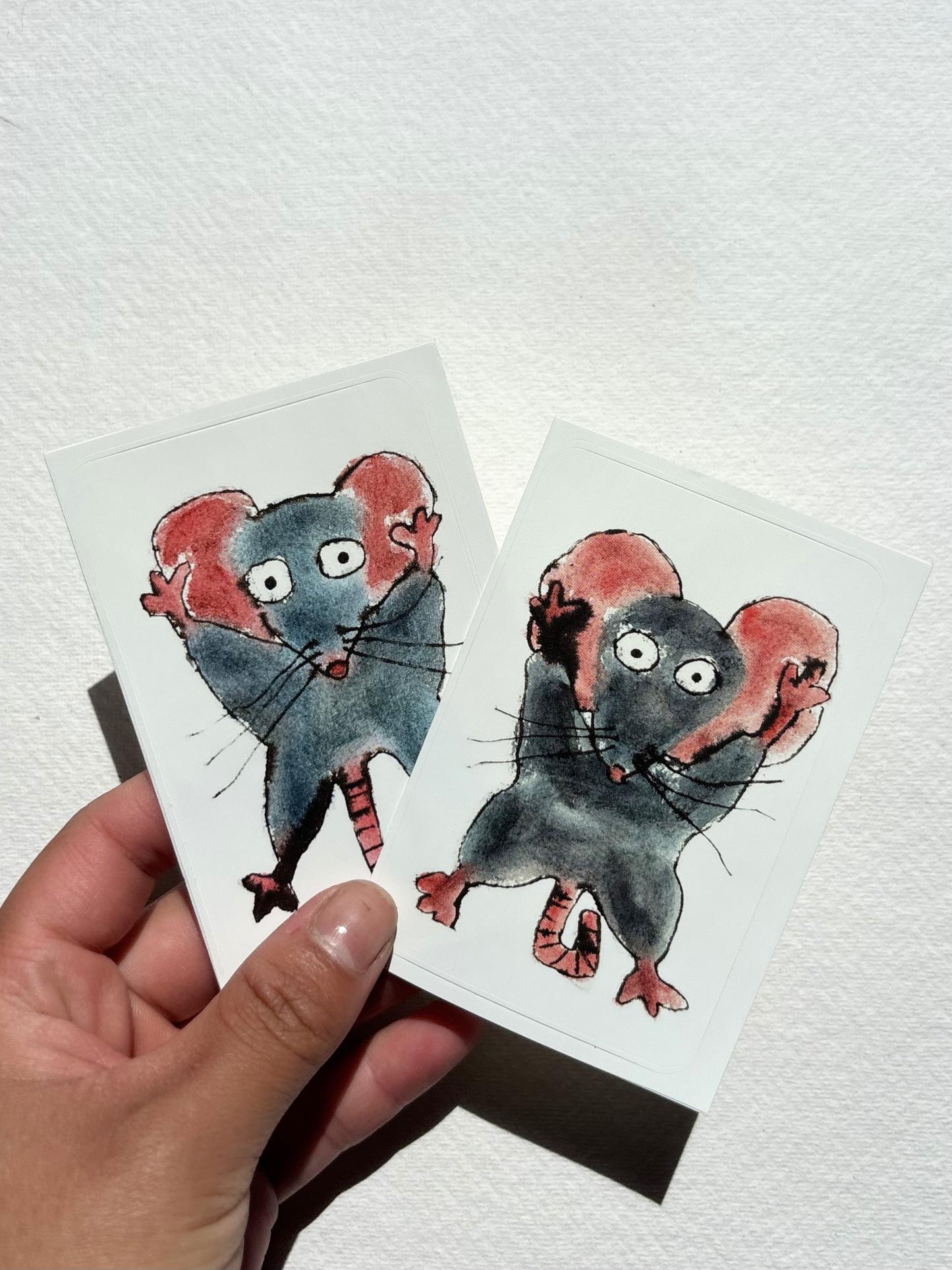 sticker featuring a hand draw vivid watercolour illustration of a cartoon mouse.