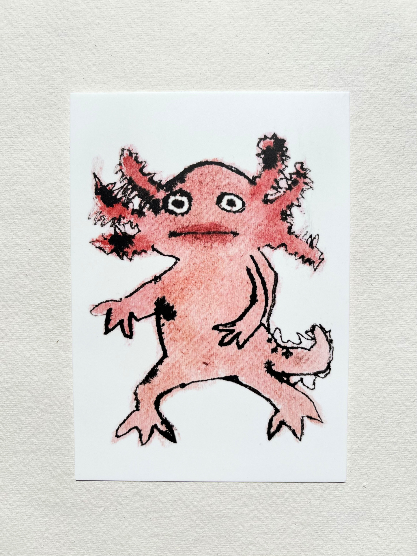 A6 postcard featuring a vivid hand draw watercolour illustration of a cartoon Axolotl.