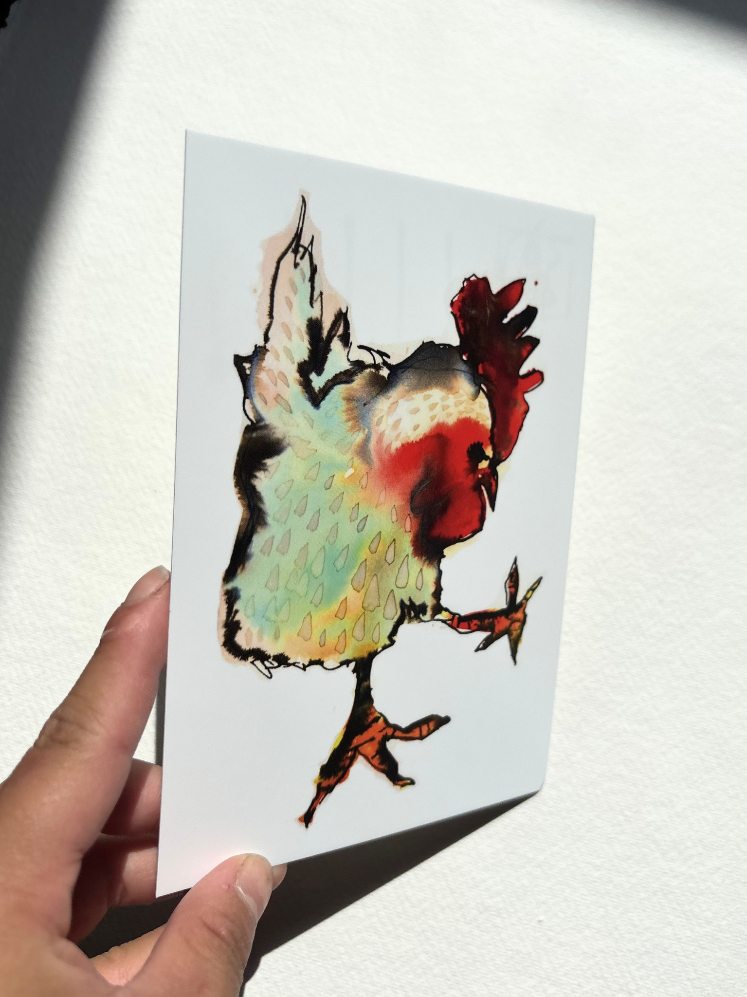  A6 postcard featuring a hand draw vivid watercolour illustration of a cartoon Cockerel.